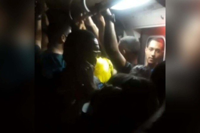 Passageiros andam pelos trilhos no túnel do metrô após descarga atmosférica