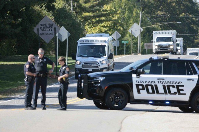 Police and emergency vehicles respond near the scene of a shooting at a church in Grand Blanc, Michigan, on September 28, 2025. One person was killed and several others injured Sunday after a shooter targeted a Mormon church in the US state of Michigan, where the building was also set on fire, authorities said.  The suspect, a 40-year-old man from a nearby town, was shot dead by law enforcement after the attack, police said, without specifying any possible motive. (Photo by Jeff Kowalsky / AFP)       
