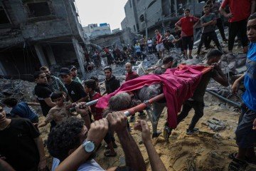 Palestinos carregam os corpos de duas irmãs, depois de bombardeio  em 24 de outubro de 2023, que matou 20 membros da família Al Faseiih -  (crédito: Saber Nuraldin)