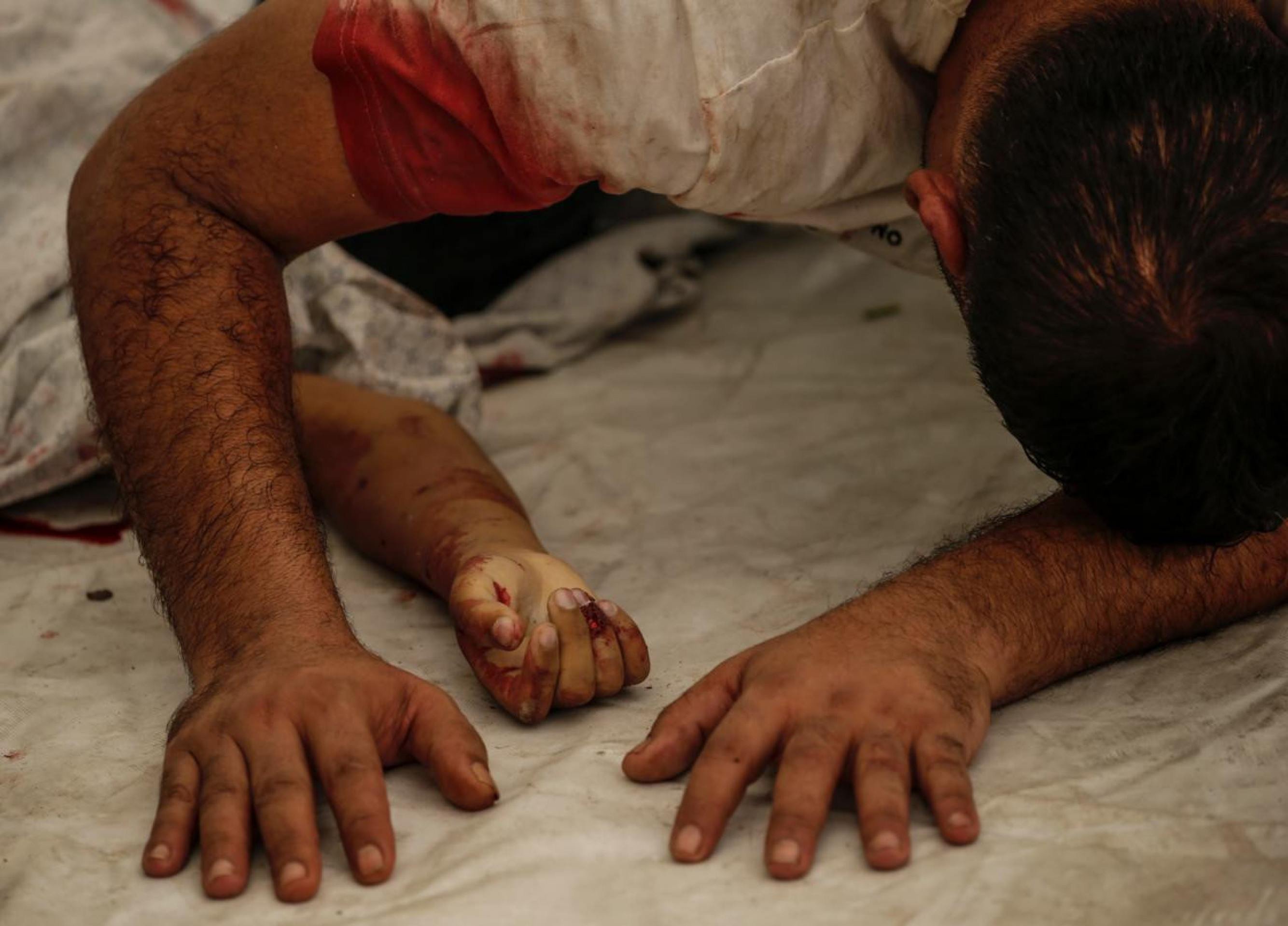 Homem chora sobre o corpo do filho, morto em 9 de outubro de 2023 