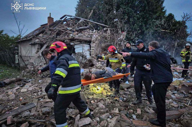 Socorristas ucranianos evacuam um jovem morador ferido após um ataque aéreo em um local não revelado na região de Lviv, em meio à invasão russa da Ucrânia -  (crédito:  AFP)