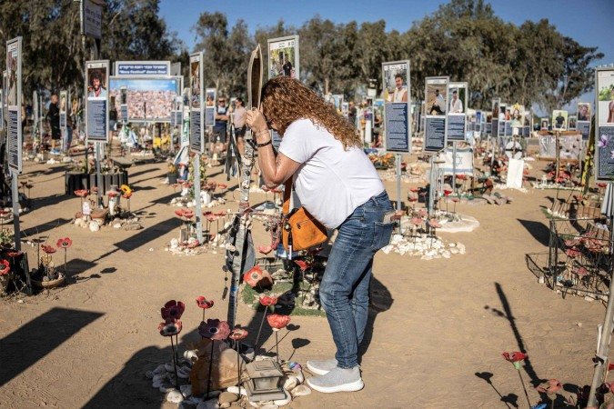 Israelense emociona-se em memorial aos mortos durante a rave do Festival Nova, no kibbutz de Re'ím, a 7km de Gaza - (crédito: John Wessels/AFP) Israelense emociona-se em memorial aos mortos durante a rave do Festival Nova, no kibbutz de Re'ím, a 7km de Gaza - (crédito: John Wessels/AFP)