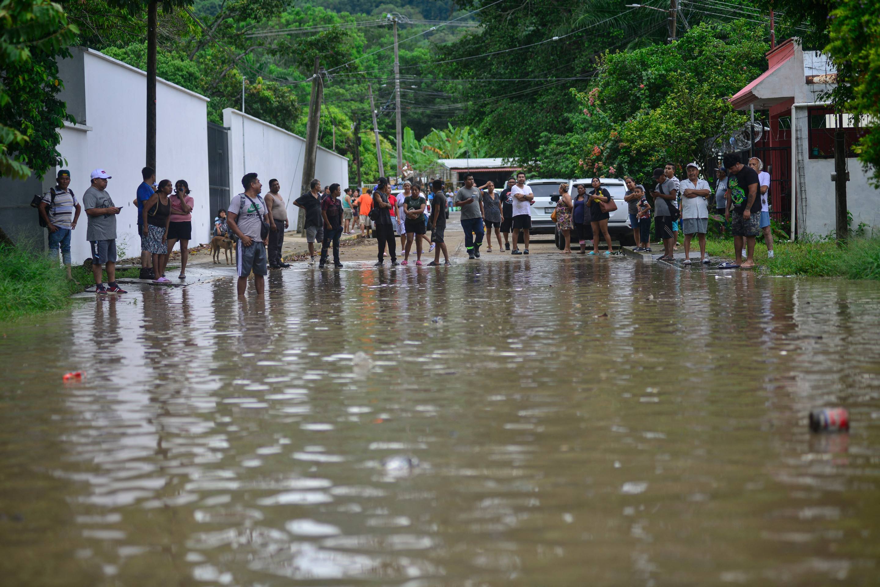 Pessoas em uma rua alagada após fortes chuvas em Poza Rica, estado de Veracruz, México, em 10 de outubro de 2025      