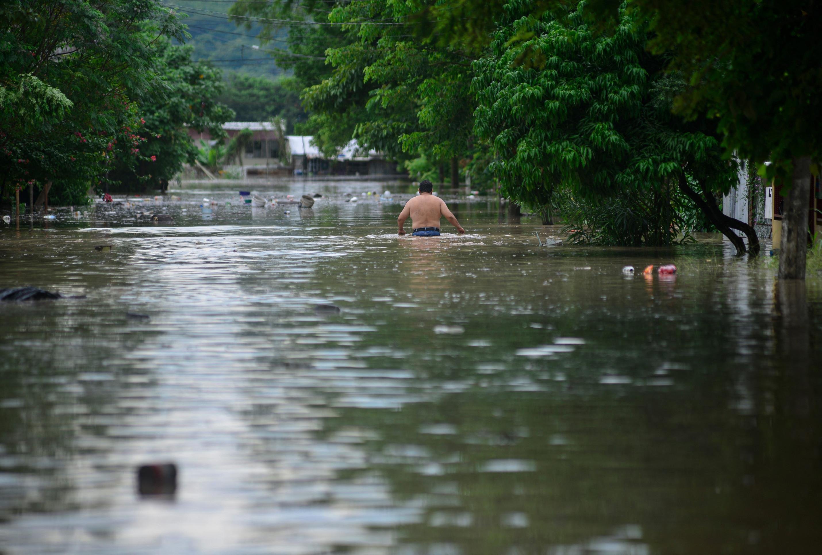 Um homem caminha por uma rua alagada após fortes chuvas em Poza Rica, estado de Veracruz, México, em 10 de outubro de 2025      