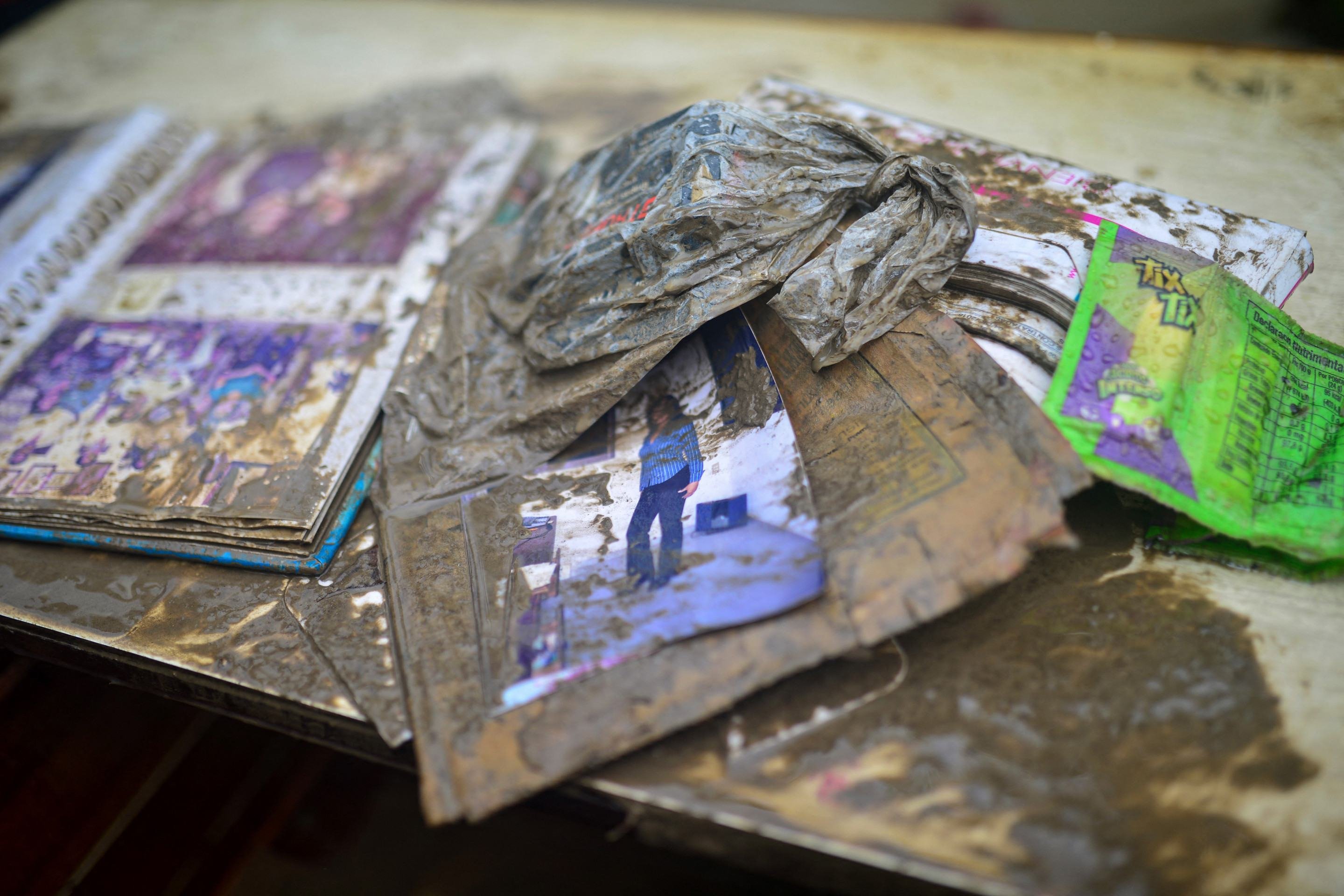 Álbuns de fotos de família cobertos de lama após fortes chuvas em Poza Rica, estado de Veracruz, México, em 10 de outubro de 2025      