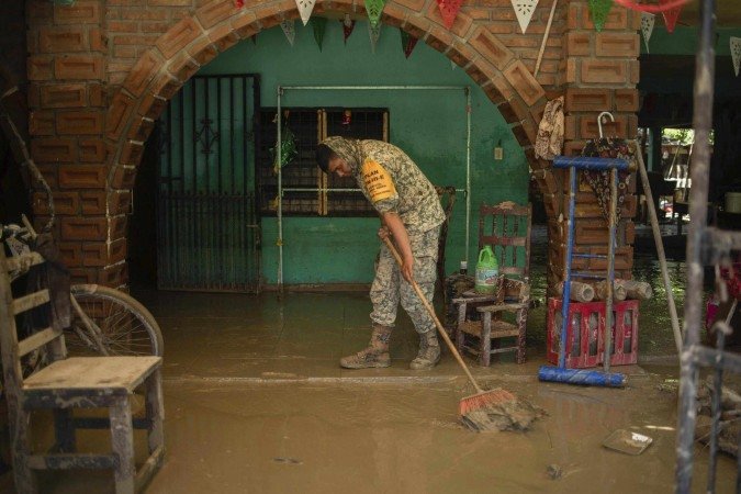  A Mexican Army soldier works to remove the mud from a flooded house due to the heavy rains in the municipality of Alamo, Veracruz state, Mexico, on October 12, 2025. The death toll from heavy rains in Mexico rose to 44 after the Mexican government confirmed three more fatalities on Sunday, as civilian and military rescuers struggle to clear roads and reach cut-off communities. (Photo by Hector Quintanar / AFP)
       -  (crédito:  AFP)