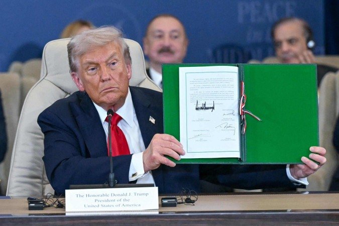 Donald Trump exibe documento assinado durante a cúpula sobre Gaza em Sharm el-Sheikh, no Egito  -  (crédito: Saul Loeb/AFP)