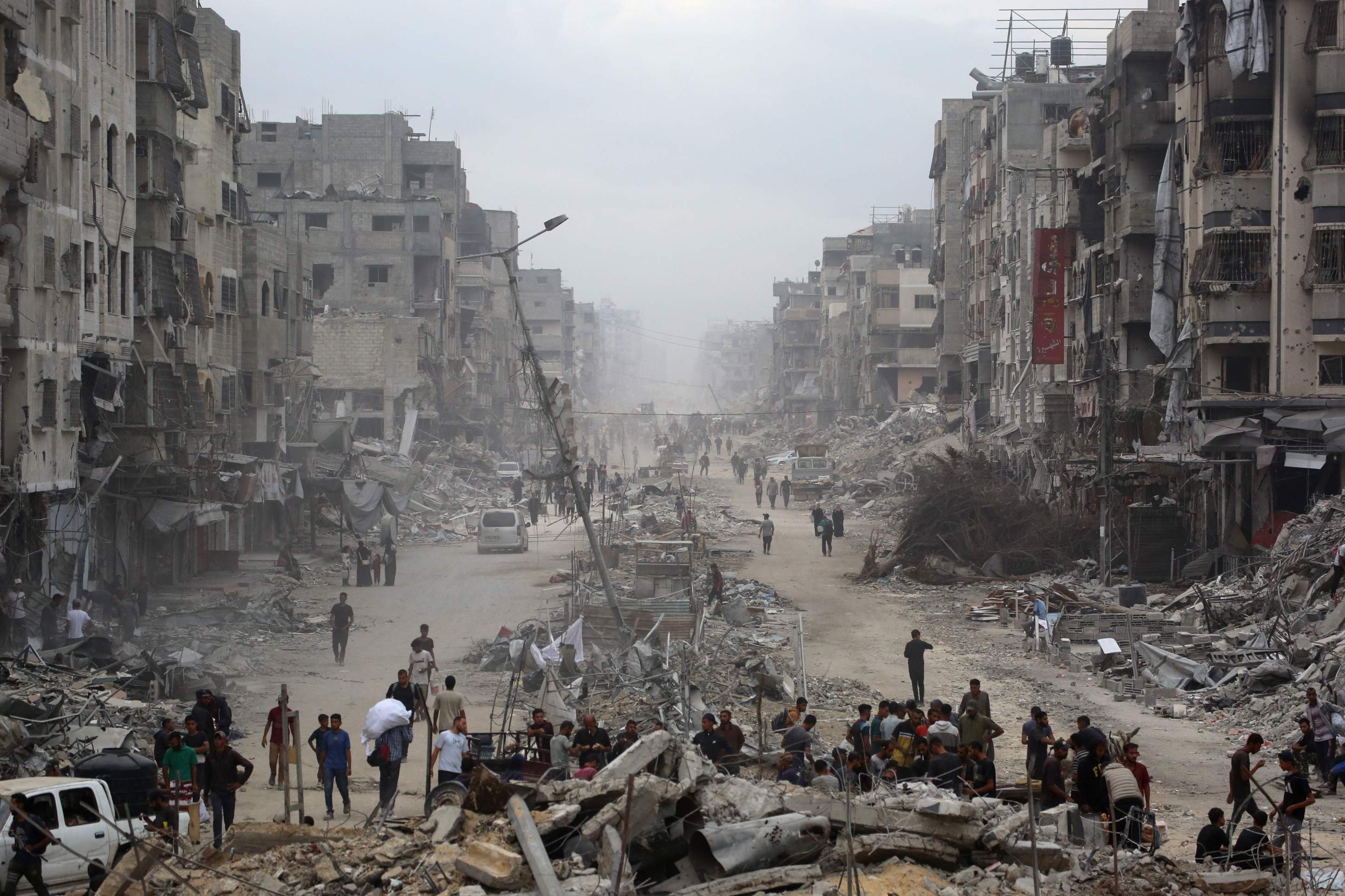 Palestinos caminham por prédios arrasados pelos bombardeios, na Cidade de Gaza 