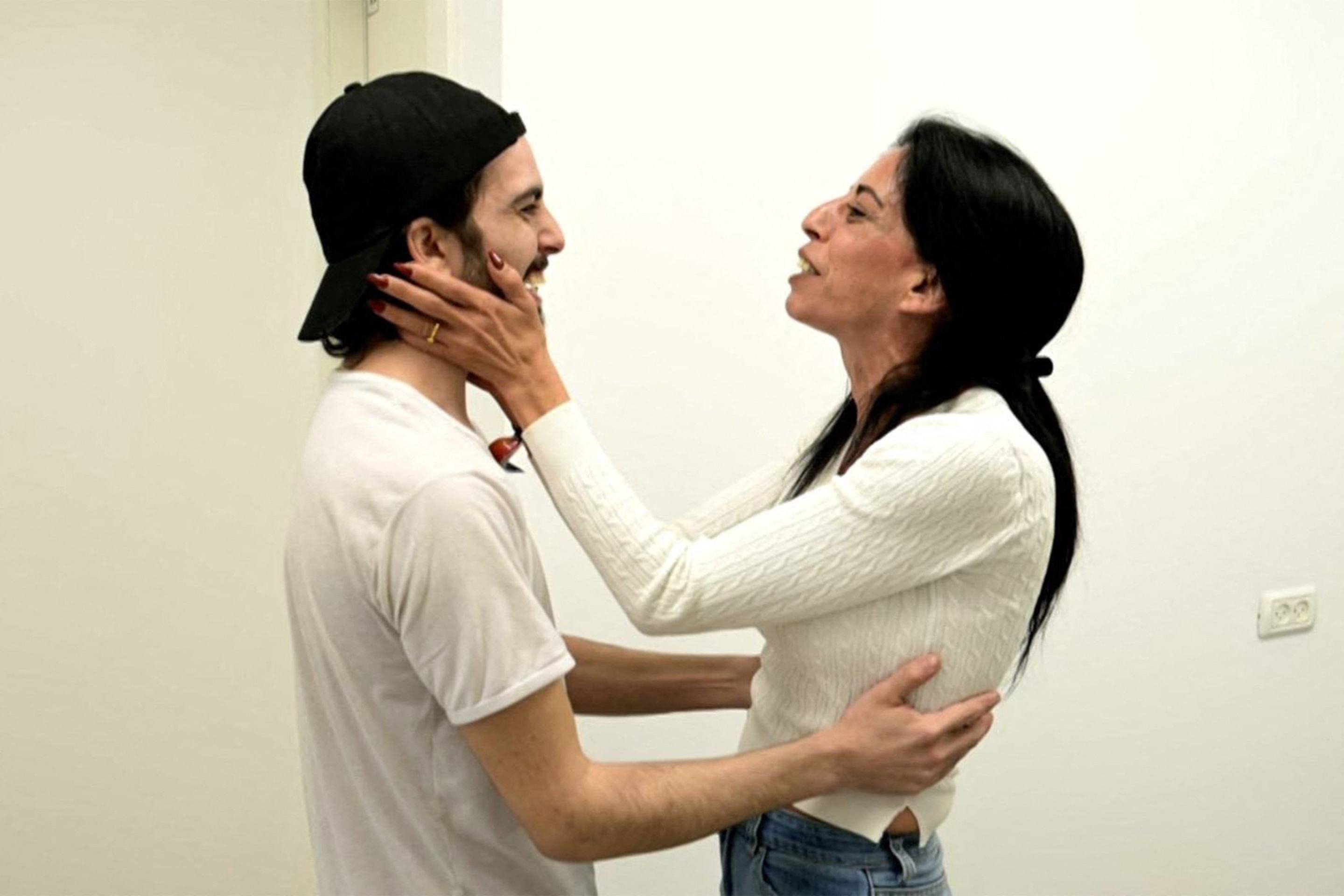 O ex-refém Matan Zangauker (E) recebe o carinho da mãe, Einav, depois de chegar a hospital em Israel 