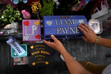 A árvore em frente ao hotel onde o cantor morreu hoje é um monumento repleto de fotos do ídolo, flores e velas que perfumam o ar sob o olhar silencioso das fãs -  (crédito:  AFP)