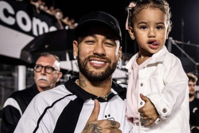 Nas imagens ainda é possível perceber que Neymar segura a filha, olha em volta para tentar identificar da onde veio a bola. Sem sucesso, ele pega a filha no colo e ambos deixam a beira do gramado enquanto ela chora -  (crédito: Raul Baretta / Santos)
