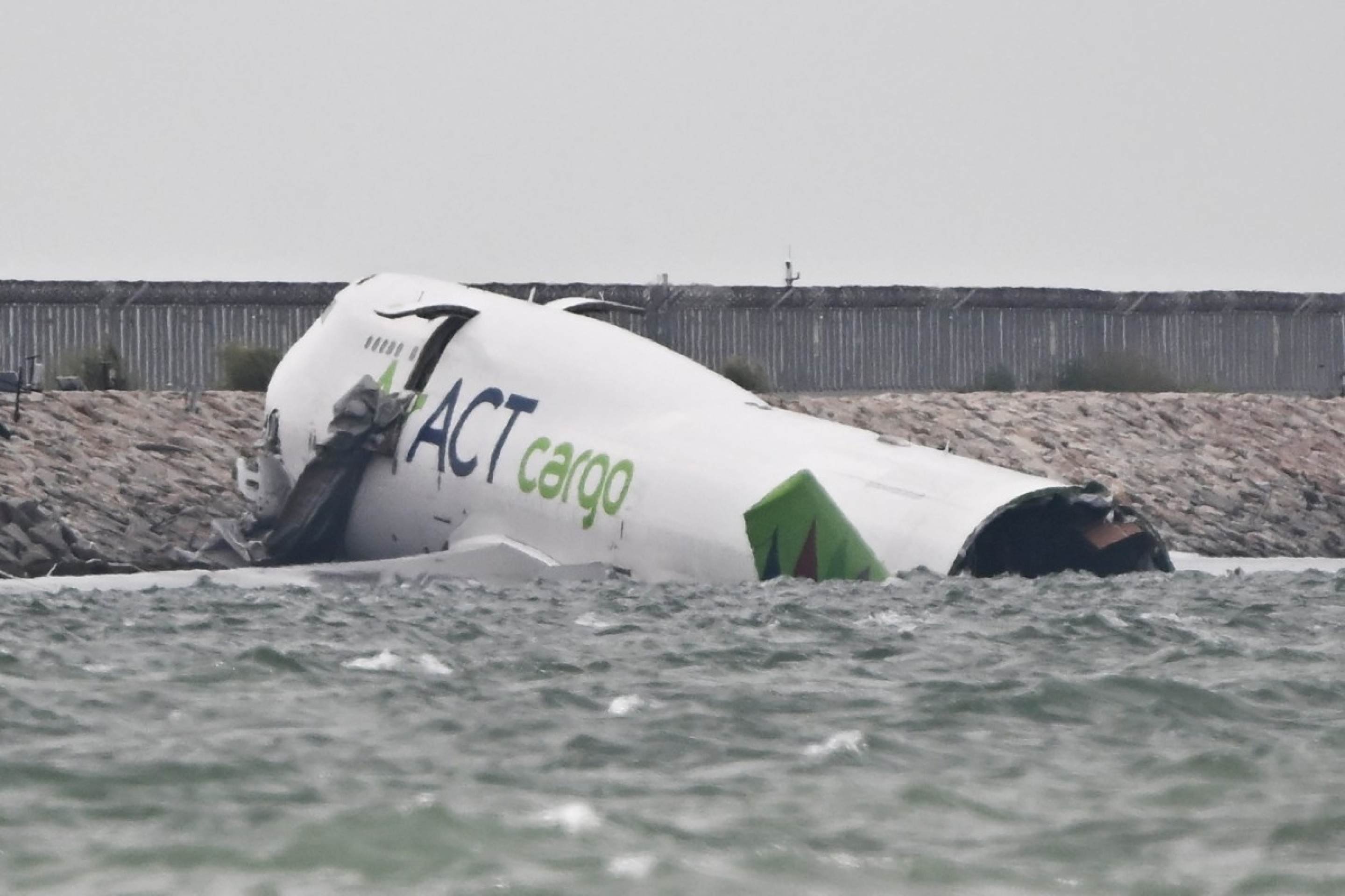 Um Boeing 747-400 de carga da ACT Airlines (E), alugado pela Emirates SkyCargo, é visto na água após sair da pista durante o pouso na pista norte do Aeroporto Internacional de Hong Kong em 20 de outubro de 2025            