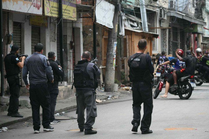 Policial faz sinal para motociclistas darem marcha ré durante a Operação Contenção na favela Vila Cruzeiro, no complexo da Penha, no Rio de Janeiro, Brasil, em 28 de outubro de 2025 - (crédito: MAURO PIMENTEL / AFP) Policial faz sinal para motociclistas darem marcha ré durante a Operação Contenção na favela Vila Cruzeiro, no complexo da Penha, no Rio de Janeiro, Brasil, em 28 de outubro de 2025 - (crédito: MAURO PIMENTEL / AFP)