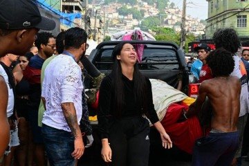  EDITORS NOTE: Graphic content / A woman cries as people unload bodies from a pickup truck on Sao Lucas Square of the Vila Cruzeiro favela at the Penha complex in Rio de Janeiro, Brazil, on October 29, 2025, in the aftermath of Operacao Contencao (Operation Containment). Residents of a favela in Rio de Janeiro lined up more than 50 bodies at a plaza in their low-income neighborhood on Ocotber 29, a day after the bloodiest police operation in the city's history, AFP reported. (Photo by Pablo PORCIUNCULA / AFP)       