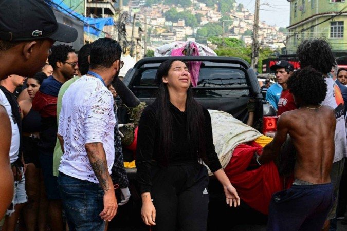 EDITORS NOTE: Graphic content / A woman cries as people unload bodies from a pickup truck on Sao Lucas Square of the Vila Cruzeiro favela at the Penha complex in Rio de Janeiro, Brazil, on October 29, 2025, in the aftermath of Operacao Contencao (Operation Containment). Residents of a favela in Rio de Janeiro lined up more than 50 bodies at a plaza in their low-income neighborhood on Ocotber 29, a day after the bloodiest police operation in the city's history, AFP reported. (Photo by Pablo PORCIUNCULA / AFP)
      