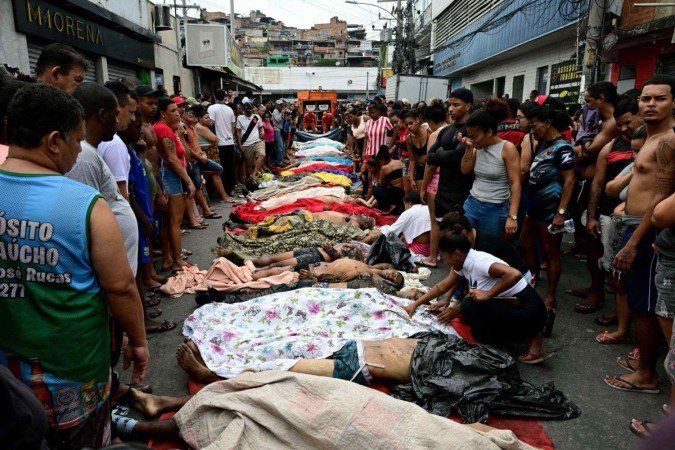EDITORS NOTE: Graphic content / People line up bodies on Sao Lucas Square of the Vila Cruzeiro favela at the Penha complex in Rio de Janeiro, Brazil, on October 29, 2025, in the aftermath of Operacao Contencao (Operation Containment). Residents of a favela in Rio de Janeiro lined up more than 50 bodies at a plaza in their low-income neighborhood on Ocotber 29, a day after the bloodiest police operation in the city's history, AFP reported. (Photo by Pablo PORCIUNCULA / AFP)
- (crédito: AFP) EDITORS NOTE: Graphic content / People line up bodies on Sao Lucas Square of the Vila Cruzeiro favela at the Penha complex in Rio de Janeiro, Brazil, on October 29, 2025, in the aftermath of Operacao Contencao (Operation Containment). Residents of a favela in Rio de Janeiro lined up more than 50 bodies at a plaza in their low-income neighborhood on Ocotber 29, a day after the bloodiest police operation in the city's history, AFP reported. (Photo by Pablo PORCIUNCULA / AFP)
- (crédito: AFP)