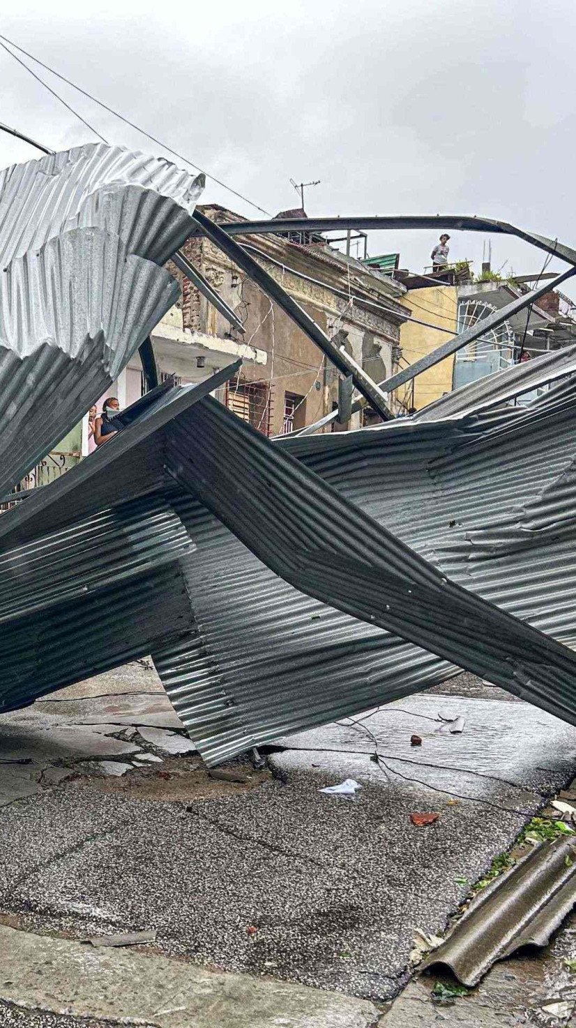  A resident sits on part of the roof of his house, damaged by Hurricane Melissa, in Santiago de Cuba on October 29, 2025. A powerful Hurricane Melissa made landfall in eastern Cuba on Wednesday, causing damage and flooding to homes and streets in Santiago de Cuba province, an AFP team on the ground reported. (Photo by YAMIL LAGE / AFP)
      Caption  -  (crédito:  AFP)
