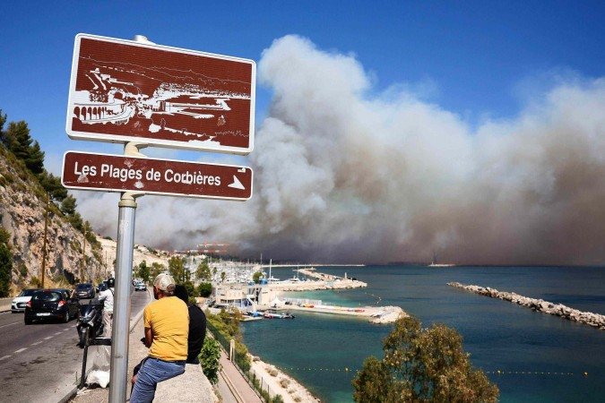 Verão europeu foi marcado por calor recorde: imagem mostra praia em Marselha, no sul da França, tomada por fumaça de incêndio em cidade vizinha - (crédito: AFP) Verão europeu foi marcado por calor recorde: imagem mostra praia em Marselha, no sul da França, tomada por fumaça de incêndio em cidade vizinha - (crédito: AFP)