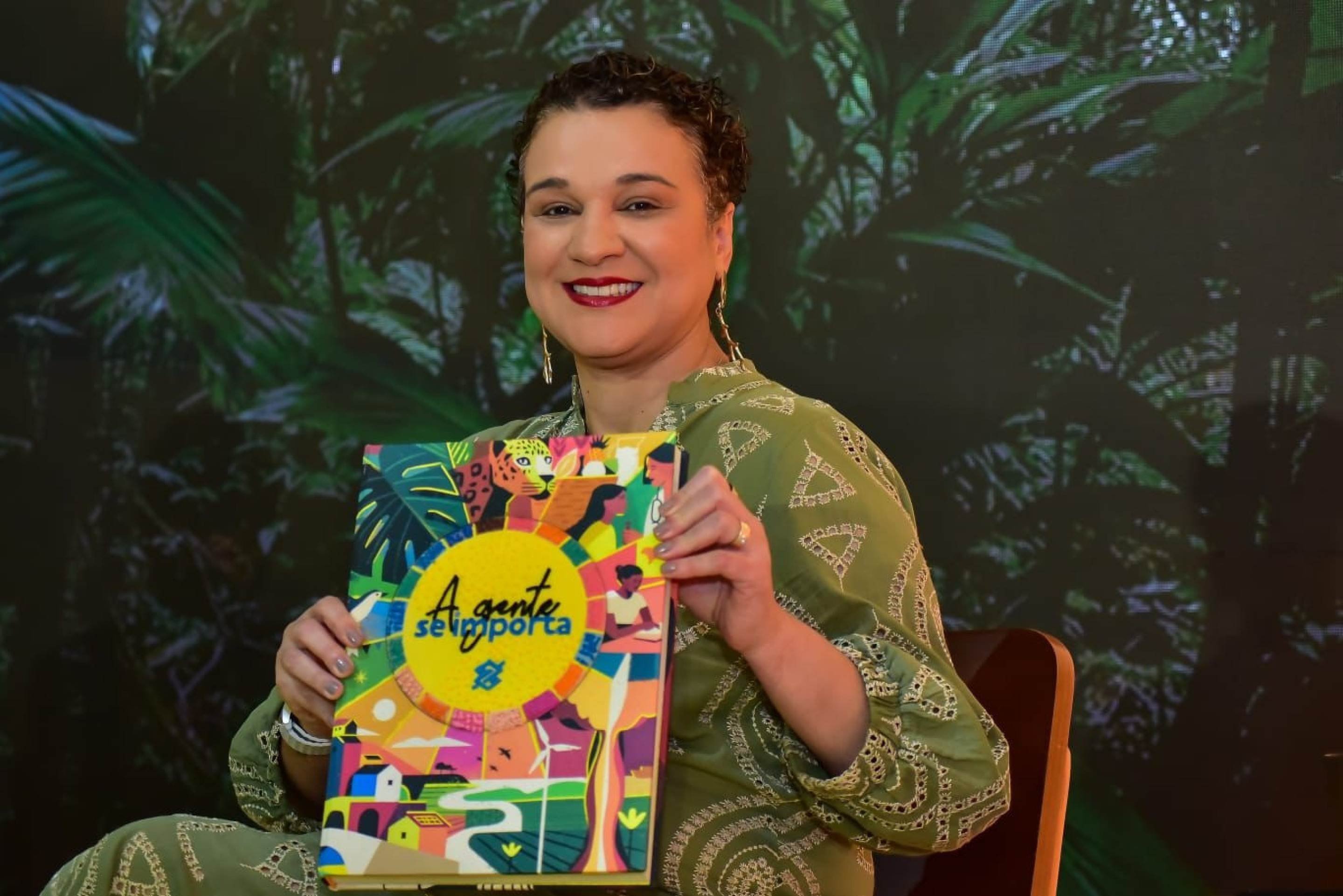 A presidente do Banco do Brasil, Tarciana Medeiros, com um exemplar do livro "A gente se importa"