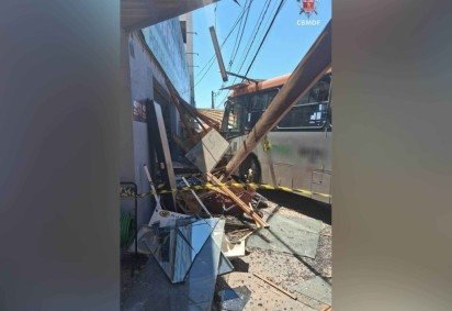 Ônibus colide com carro estacionado e destrói fachada comercial