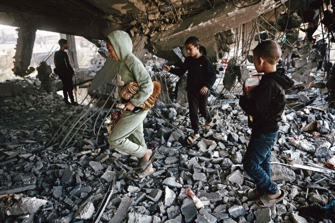 Crianças palestinas vasculham escombros do Prédio do Ministério das Doações religiosas, em Gaza, após novo ataque israelense nesta quarta (19) -  (crédito: Omar Al-Qattaa/ Agência France-Presse )