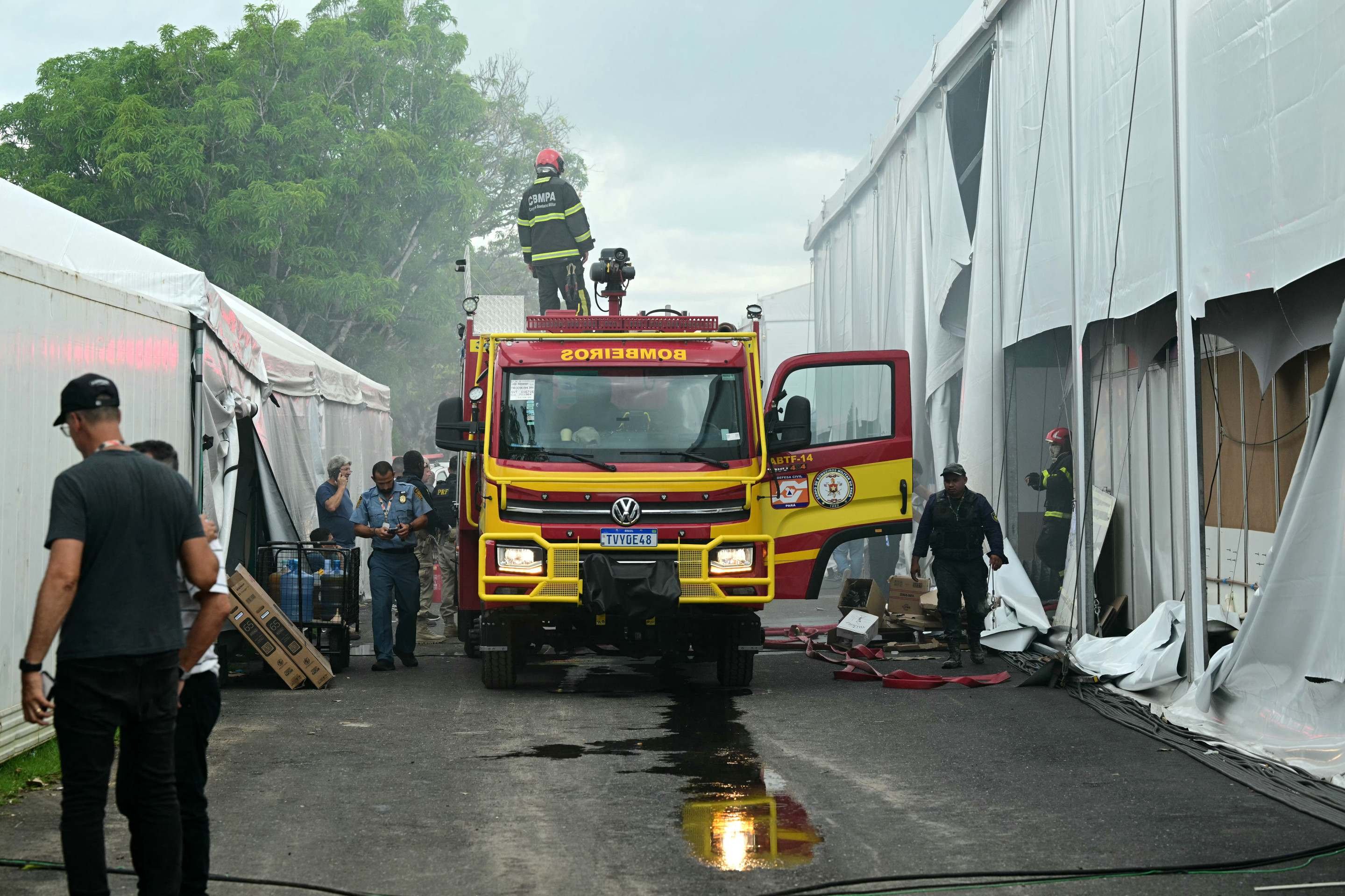  Forefighters work after a fire broke out in a pavilion during the COP30 UN Climate Change Conference in Belem, Para state, Brazil, on November 20, 2025. A fire erupted at a pavilion inside the venue of the UNs climate talks in Brazil on Thursday, prompting panicked delegates to run for the exits, AFP journalists said. Emergency crews rushed to try to put out the blaze as smoke engulfed the corridor. (Photo by Pablo PORCIUNCULA / AFP)       