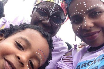 Jussara (ao centro), a filha Jerusa e o neto Akin na Marcha das Mulheres Negras em 2015