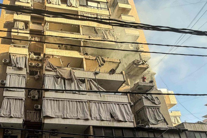 Homem grita da varanda destruída de prédio residencial atingido por Israel, em Haret Hreik, bairro na região sul de Beirute  -  (crédito: Ibrahim Amro/AFP)