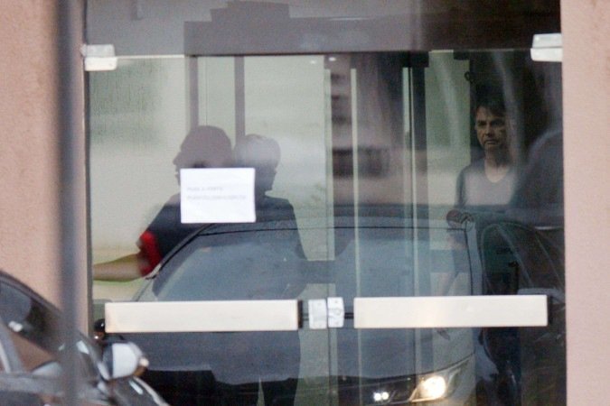 O ex-presidente Jair Bolsonaro (PL), à direita, atrás de vidraça no prédio da Superintendência da Polícia Federal, em Brasília -  (crédito: Ed Alves/CB)