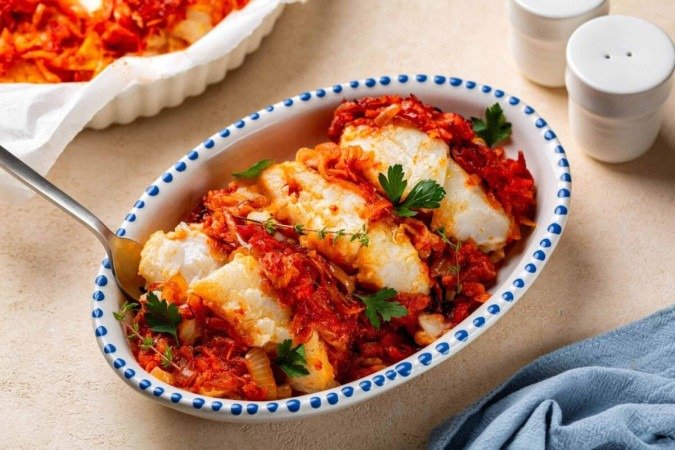 Bacalhau ao forno com molho de tomate (Imagem: OlgaBombologna | Shutterstock) - (crédito: EdiCase) Bacalhau ao forno com molho de tomate (Imagem: OlgaBombologna | Shutterstock) - (crédito: EdiCase)