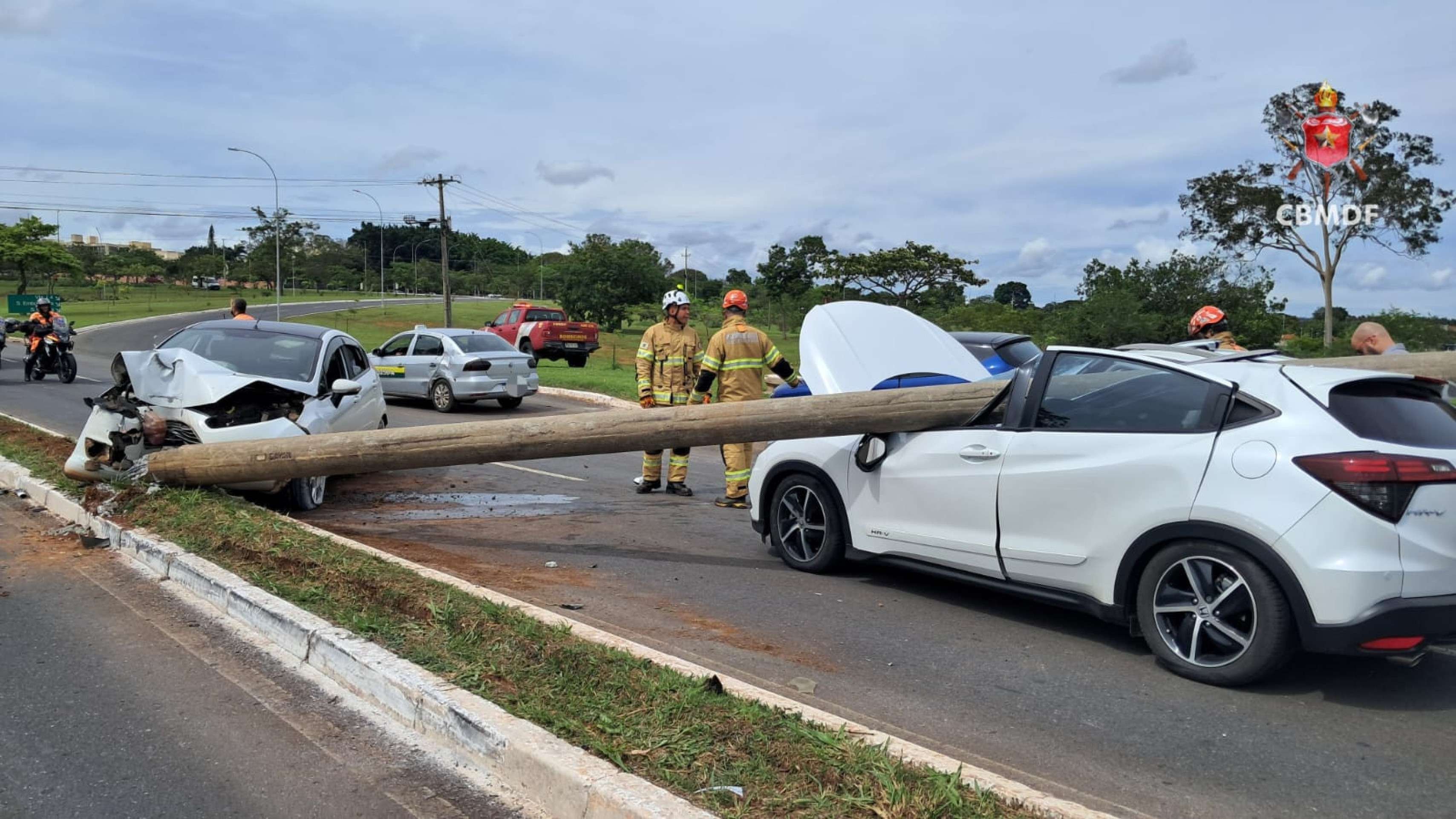 Dois carros colidem e poste de iluminação cai sobre outro veículo