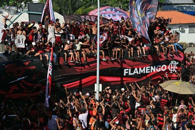 Fanáticos subiram no ônibus do Flamengo nas proximidades do Galeão e alguns até entraram pelo teto para ter contato com os jogadores: cenas filmadas pelos atletas -  (crédito:  Pablo Porciuncula/AFP)