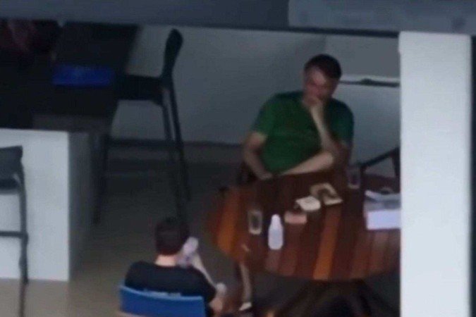 Nikolas Ferreira (PL-MG) durante visita ao ex-presidente Jair Bolsonaro, flagrado usando celular, ação proibida por decisão do STF
 -  (crédito: Reprodução/TV Globo)