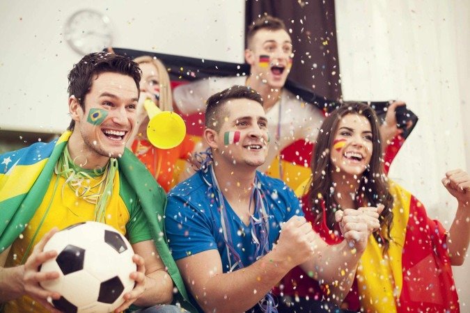  Multinational football supporters celebrating goal.
     -  (crédito:  Anna Bizon)