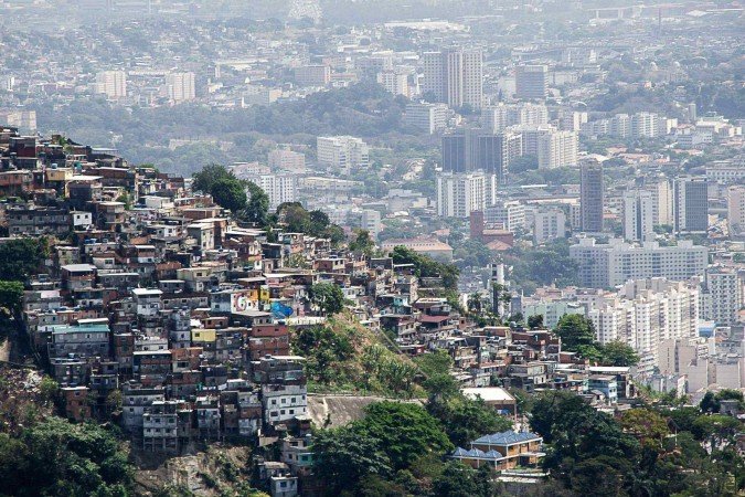 Placa assinada pelo Comando Vermelho em comunidade; facção tem o maior número de pessoas dominadas ou influenciadas por sua atuação  -  (crédito: MAURO PIMENTEL/AFP via Getty Images)