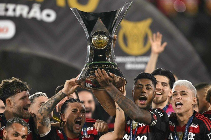 O cabelo de Arrascaeta muda, mas o apetite por troféus, não! Ele e o parceiro Bruno Henrique atingiram a marca de 17 títulos com a camisa rubro-negra desde 2019: os jogadores mais vitoriosos na história do clube - (crédito: AFP) O cabelo de Arrascaeta muda, mas o apetite por troféus, não! Ele e o parceiro Bruno Henrique atingiram a marca de 17 títulos com a camisa rubro-negra desde 2019: os jogadores mais vitoriosos na história do clube - (crédito: AFP)