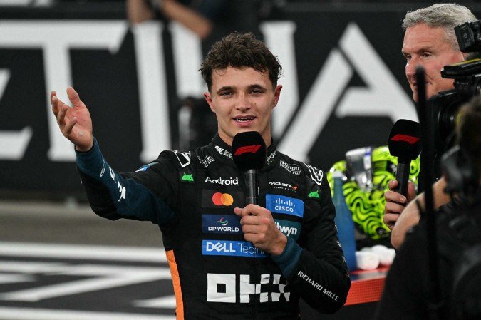 O piloto britânico da McLaren, Lando Norris, discursa enquanto comemora a conquista do título mundial de Fórmula 1 no final do Grande Prêmio de Abu Dhabi, no Circuito de Yas Marina, em Abu Dhabi, em 7 de dezembro de 2025.        -  (crédito:  Andrej Isakovic / Agência France-Presse)