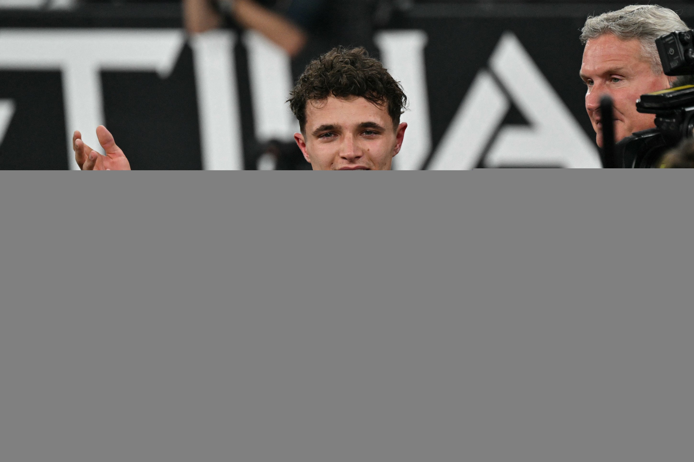 O piloto brit&acirc;nico da McLaren, Lando Norris, discursa enquanto comemora a conquista do t&iacute;tulo mundial de F&oacute;rmula 1 no final do Grande Pr&ecirc;mio de Abu Dhabi, no Circuito de Yas Marina, em Abu Dhabi, em 7 de dezembro de 2025.