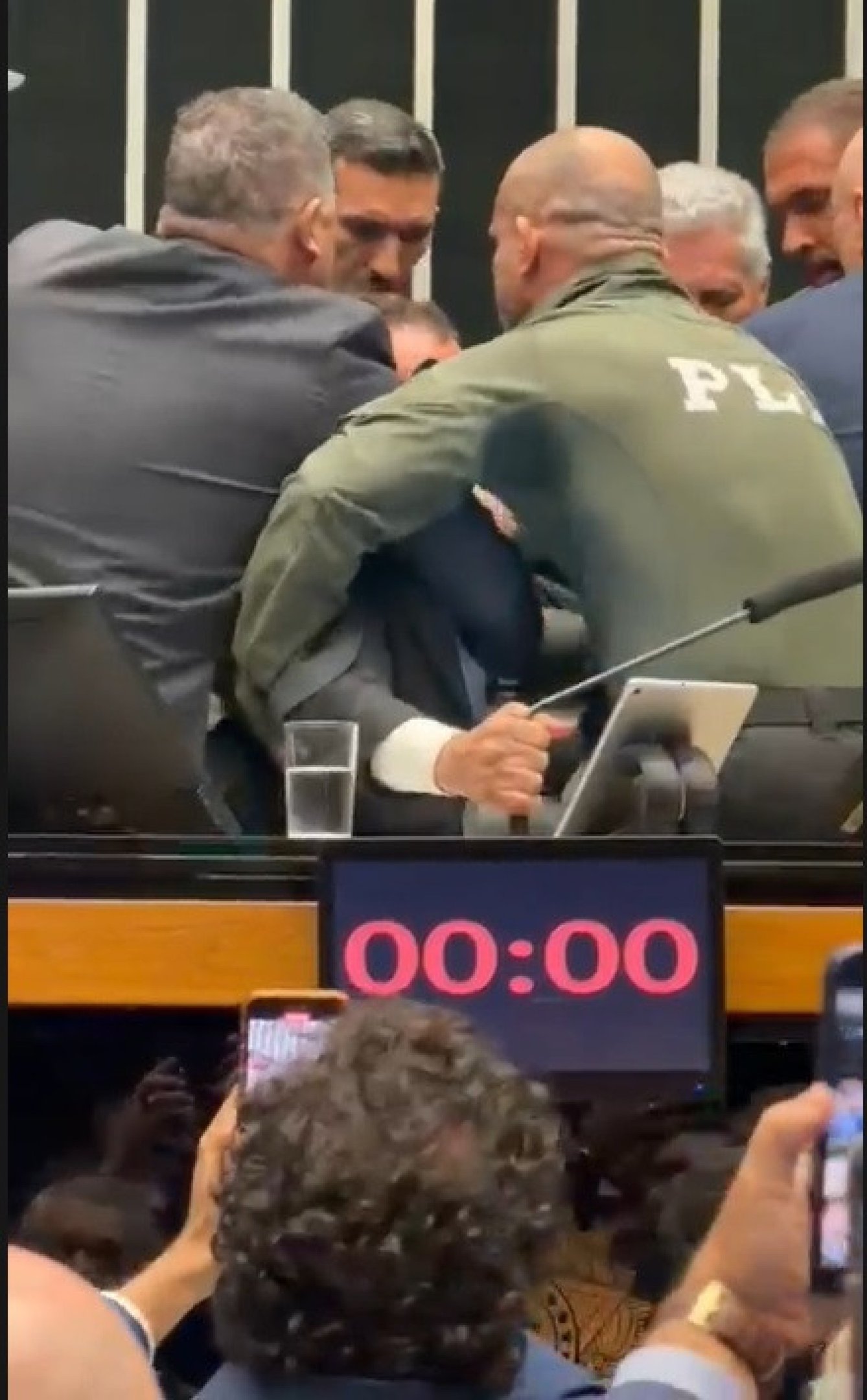  Deputado federal Glauber Braga (PSOL-RJ) é visto em meio a tumulto após ter sido retirado à força pela Polícia Legislativa da Mesa da Câmara dos Deputados, em Brasília, no final da tarde desta terça-feira, 9 de dezembro de 2025. A imprensa não conseguiu acompanhar a retirada de Glauber, que ocupou a cadeira ocupada pelo presidente da Câmara, Hugo Motta (Republicanos-PB), por se opor à votação do projeto de lei que diminui as penas de condenados pelos atos de 8 de Janeiro.