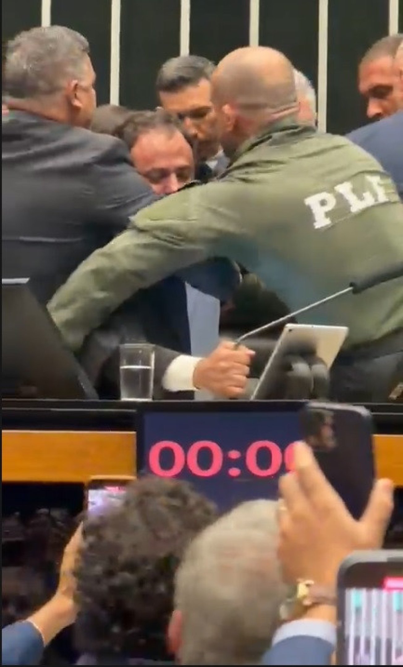  Deputado federal Glauber Braga (PSol-RJ) é visto em meio a tumulto após ter sido retirado à força pela Polícia Legislativa da Mesa da Câmara dos Deputados, em Brasília