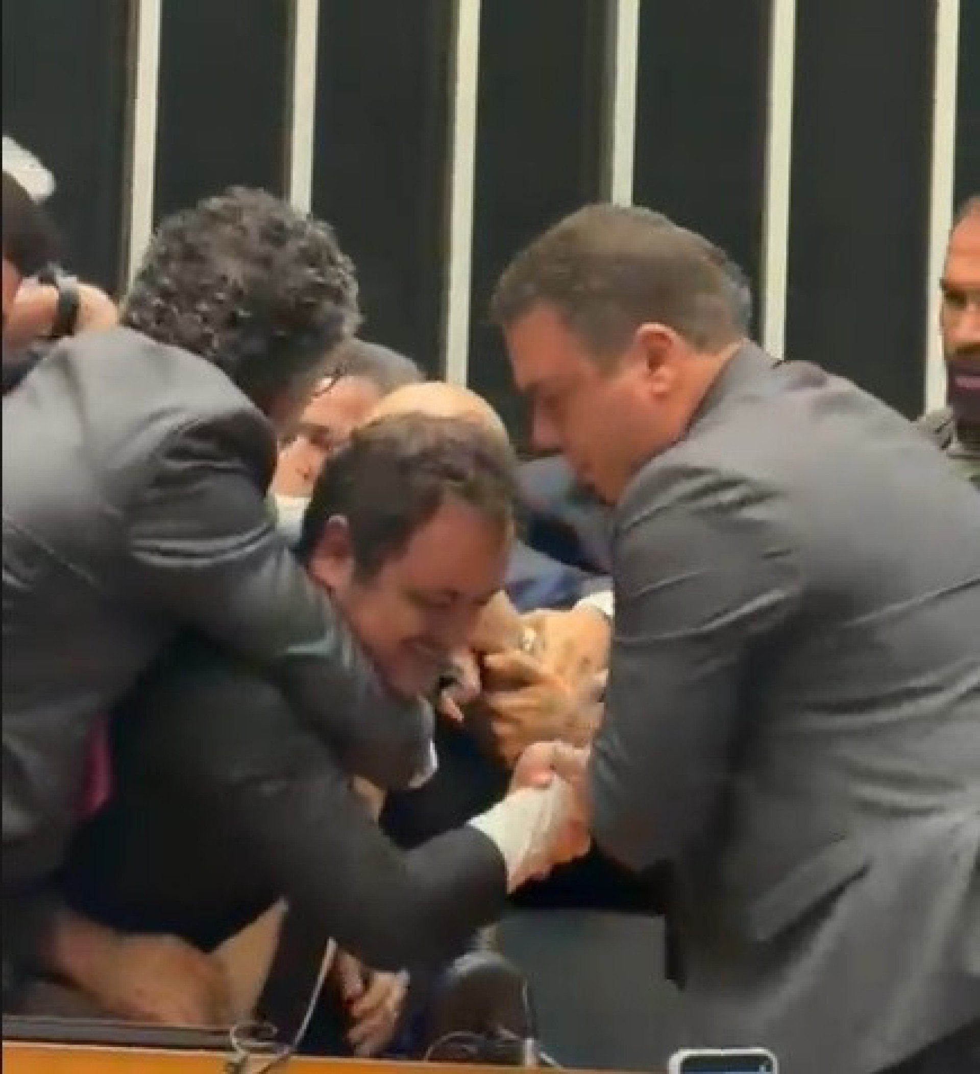 Deputado federal Glauber Braga (PSOL-RJ) é visto em meio a tumulto após ter sido retirado à força pela Polícia Legislativa da Mesa da Câmara dos Deputados, em Brasília, no final da tarde desta terça-feira, 9 de dezembro de 2025. A imprensa não conseguiu acompanhar a retirada de Glauber, que ocupou a cadeira ocupada pelo presidente da Câmara, Hugo Motta (Republicanos-PB), por se opor à votação do projeto de lei que diminui as penas de condenados pelos atos de 8 de Janeiro.