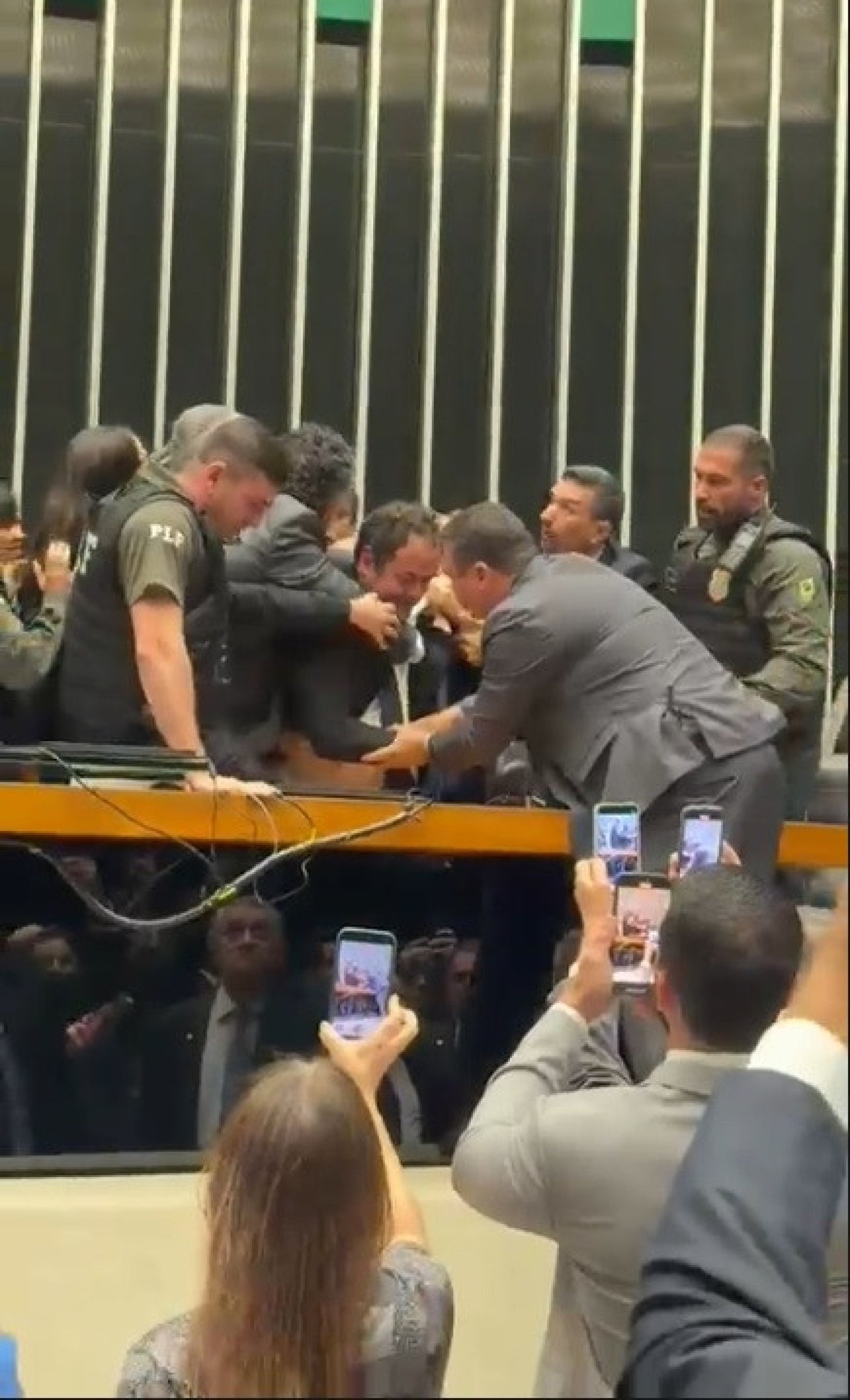  Deputado federal Glauber Braga (PSOL-RJ) é visto em meio a tumulto após ter sido retirado à força pela Polícia Legislativa da Mesa da Câmara dos Deputados, em Brasília, no final da tarde desta terça-feira, 9 de dezembro de 2025. A imprensa não conseguiu acompanhar a retirada de Glauber, que ocupou a cadeira ocupada pelo presidente da Câmara, Hugo Motta (Republicanos-PB), por se opor à votação do projeto de lei que diminui as penas de condenados pelos atos de 8 de Janeiro.