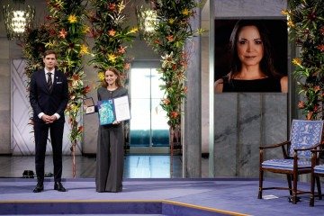 Ana Corina Sosa (D), filha de María Corina Machado, exibe a medalha e o diploma do Nobel da Paz, em solenidade na capital da Noruega
- (crédito: Ole Berg-Rusten/NTB/AFP) Ana Corina Sosa (D), filha de María Corina Machado, exibe a medalha e o diploma do Nobel da Paz, em solenidade na capital da Noruega
- (crédito: Ole Berg-Rusten/NTB/AFP)