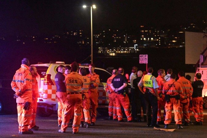 Equipes de emergência se reúnem no local após um tiroteio na praia de Bondi, em Sydney, em 14 de dezembro de 2025 - (crédito: SAEED KHAN / AFP) Equipes de emergência se reúnem no local após um tiroteio na praia de Bondi, em Sydney, em 14 de dezembro de 2025 - (crédito: SAEED KHAN / AFP)