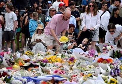  Mourners pay a floral tribute to Bondi Beach shooting victims at the Bondi Pavilion in Sydney on December 15, 2025. A father-and-son team toting long-barrelled guns shot and killed 15 people including a 10-year-old girl at Sydney's Bondi Beach on December 14, with authorities labelling it an antisemitic terrorist attack on a Jewish festival. (Photo by Saeed KHAN / AFP)
       -  (crédito:  AFP) - Mourners pay a floral tribute to Bondi Beach shooting victims at the Bondi Pavilion in Sydney on December 15, 2025. A father-and-son team toting long-barrelled guns shot and killed 15 people including a 10-year-old girl at Sydney's Bondi Beach on December 14, with authorities labelling it an antisemitic terrorist attack on a Jewish festival. (Photo by Saeed KHAN / AFP)
       -  (crédito:  AFP)