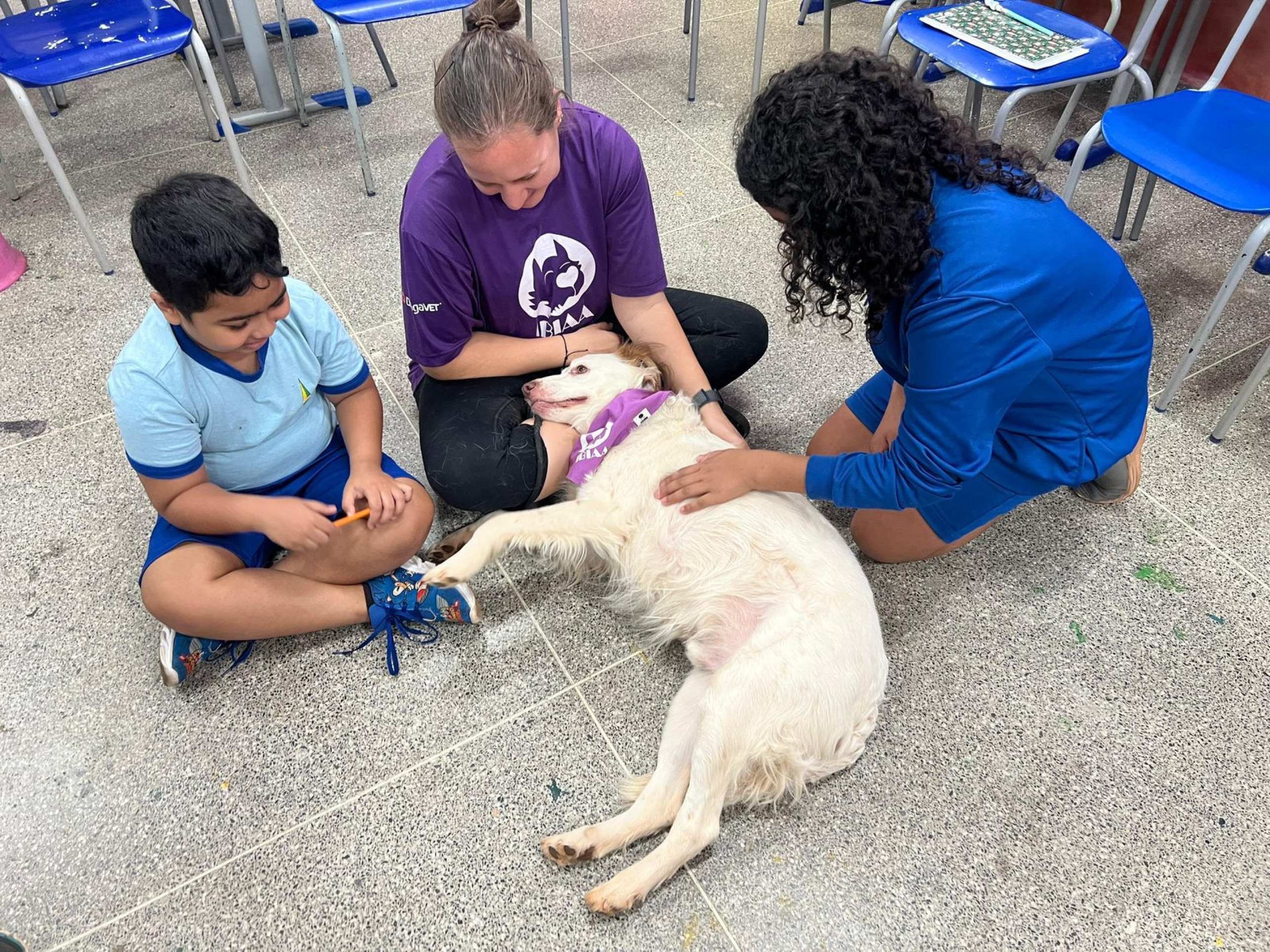 Alunos fazem carinho em Milo, um dos c&atilde;es volunt&aacute;rios do IBIAA