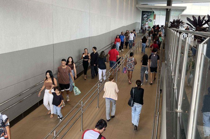 Consumidores chegando e saindo de Shopping JK