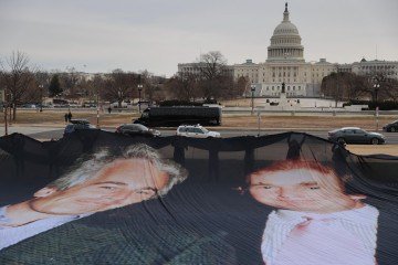Faixa com a foto de Trump e Epstein estendida em frente ao Capitólio: busca interminável por justiça -  (crédito: Heather Diehl/Getty Images/AFP)