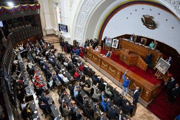 Deputados da Assembleia Nacional erguem as mãos ao votarem a favor do projeto de lei, no Palácio Federal Legislativo, em Caracas  -  (crédito: Federico Parra/AFP)