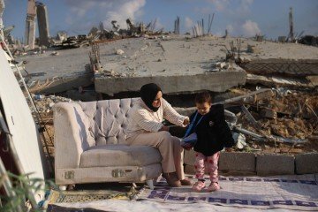 Nibal Al-Hissi, 25, e a filha Rita, 2, do lado de fora de sua casa, em Jabalia, norte de Gaza